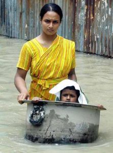 Bangladeshi woman with her child wading through flood waters in Sirajgonj , about 100km northwest of Dhaka